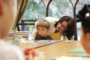 A teacher works with a young student during a Greek-language class at a community school in the United States
