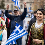 Participants in traditional Greek attire carry flags during the Greek Independence Day parade in Philadelphia.