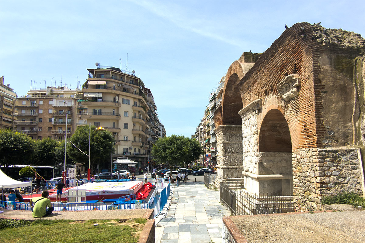 Arch of Galerius (Kamara) in Thessaloniki, Greece, surrounded by city buildings and people, 2025.