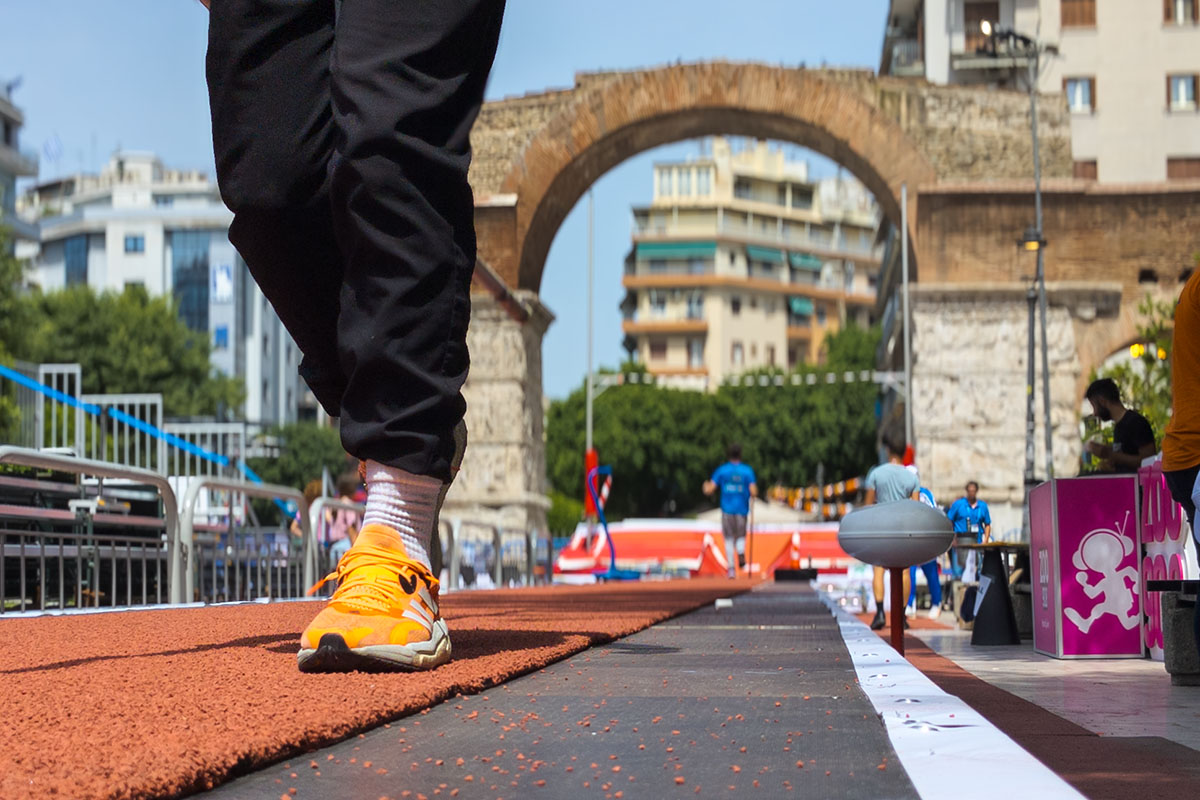 Runner with orange shoes at an athletics event in front of the Arch of Galerius (Kamara), Thessaloniki, Greece, 2025.