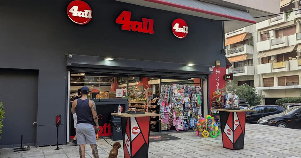 4ALL minimarket storefront with toys, snacks, and a customer standing outside with a dog.