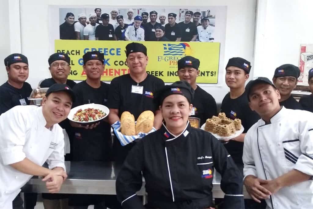 Filipino culinary students pose with traditional Greek dishes at the El Greco Cooking Center near Manila