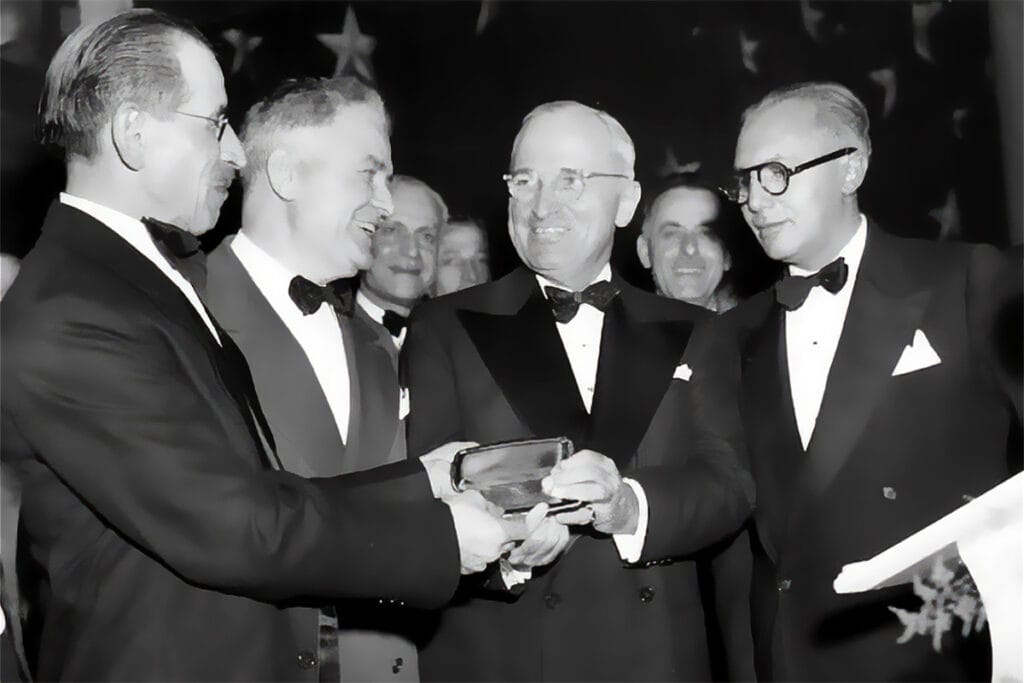 President Harry S. Truman receiving an AHEPA Gold Life Membership Card at the 1948 AHEPA National Banquet in Washington, D.C., with Chris G. Garrison, Thomas Kapsemalis, and William Helis