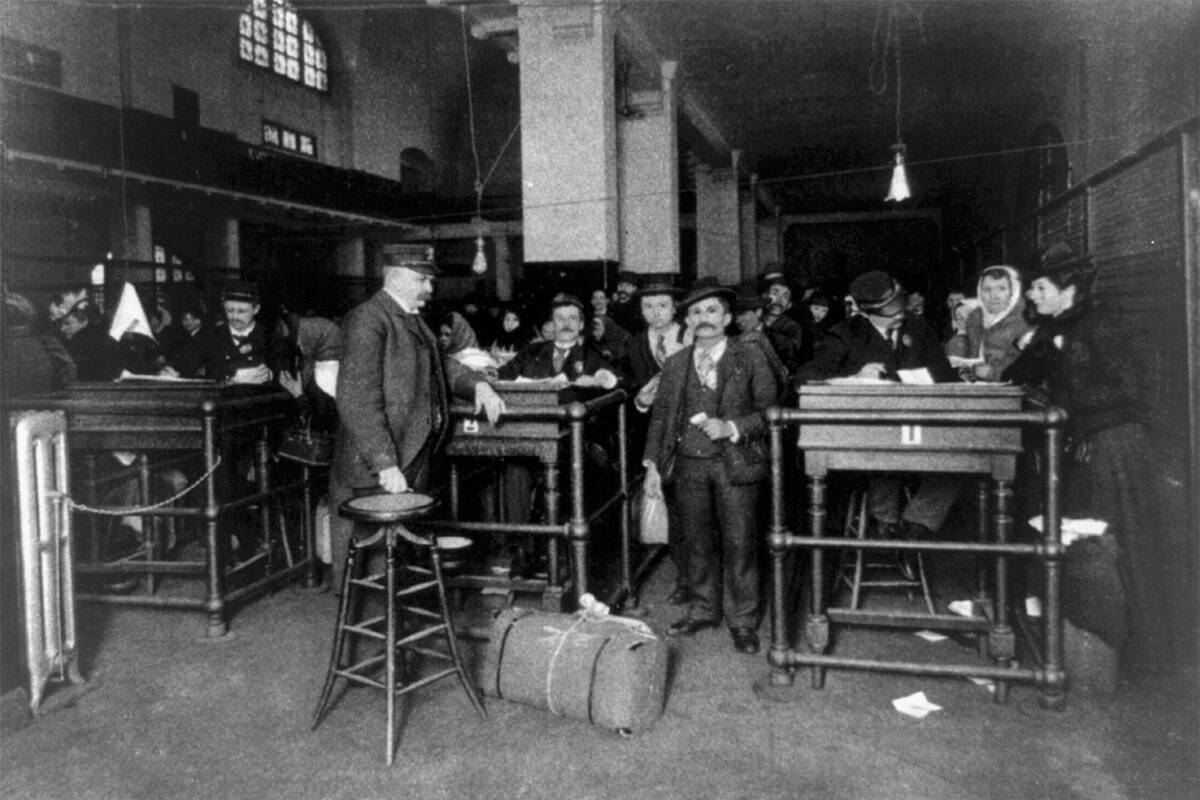 Immigrants being examined by officers at Ellis Island Immigration Station, 1902.
