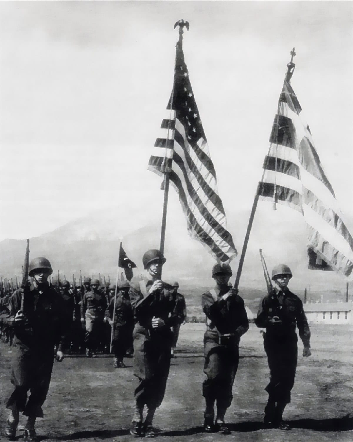 Soldiers of the U.S. Army 122nd Infantry “Greek Battalion” parade at Camp Carson, Colorado, April 24, 1943, carrying U.S. and Greek flags.