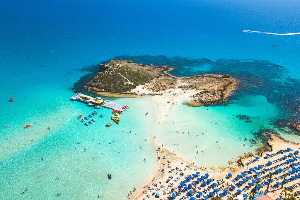 Aerial view of Nissi Beach in Agia Napa, Cyprus, with turquoise waters, sunbeds, and swimmers