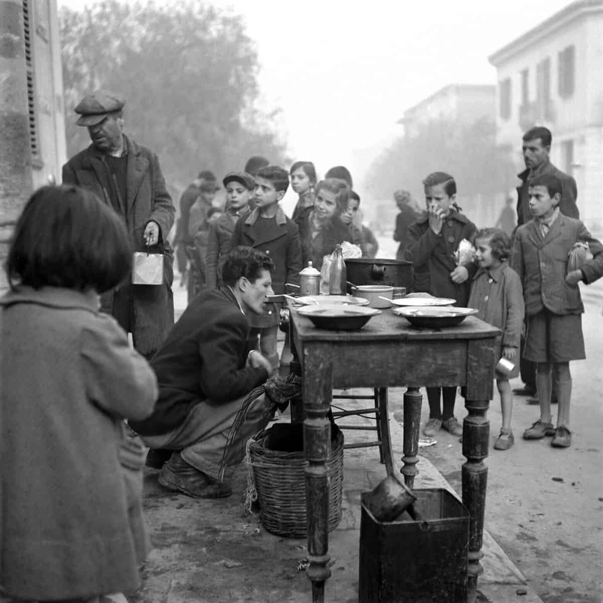 Children and adults waiting at a soup kitchen in Athens during the wartime famine, photographed by Voula Papaioannou