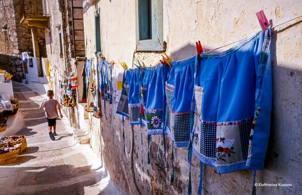 Brightly colored aprons hanging on a clothesline along an Olympos village street