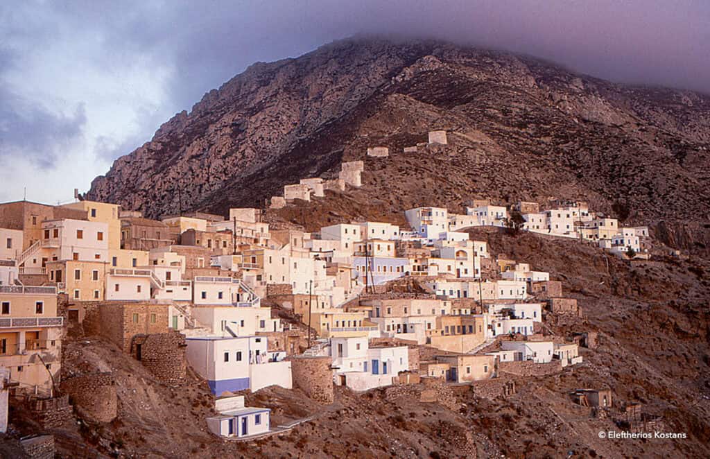 Wide view of the mountain village of Olympos with houses climbing the rocky slope