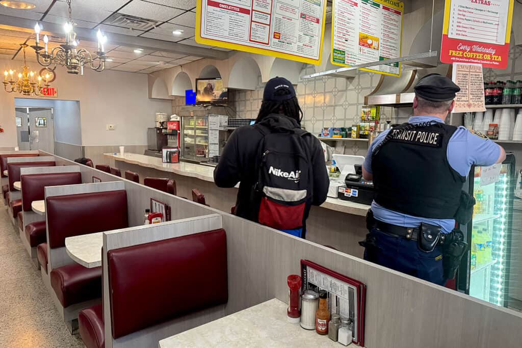 Current interior of Aquarius Restaurant showing red booths, chandeliers, and open counter.