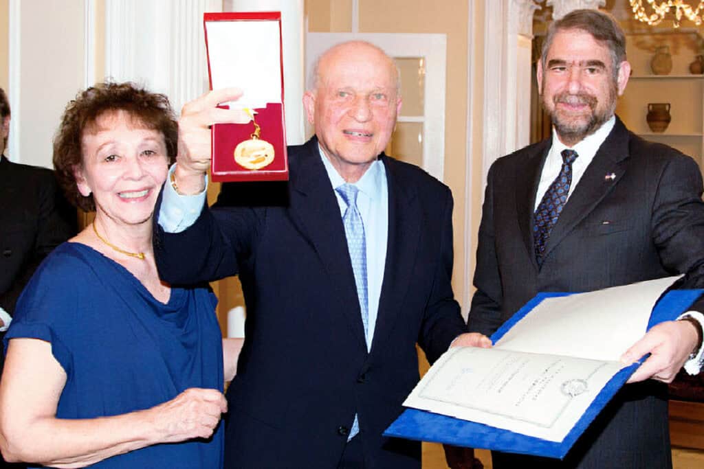 Aphrodite Rossides, Gene Rossides, and Ambassador Pantelides as Gene Rossides displays the Republic of Cyprus Presidential Exceptional Service Medal.