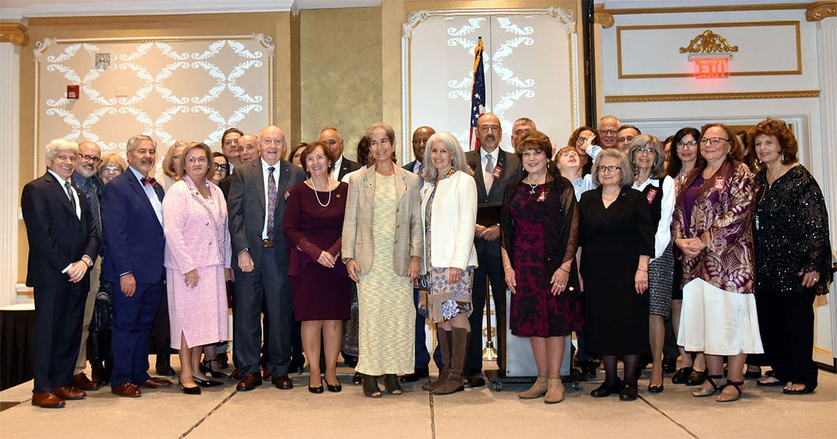 Attendees of the 14th Annual IOCC Benefit Banquet in Deptford, New Jersey, gathered on stage at the Adelphia Pan Athenian Grand Ballroom.