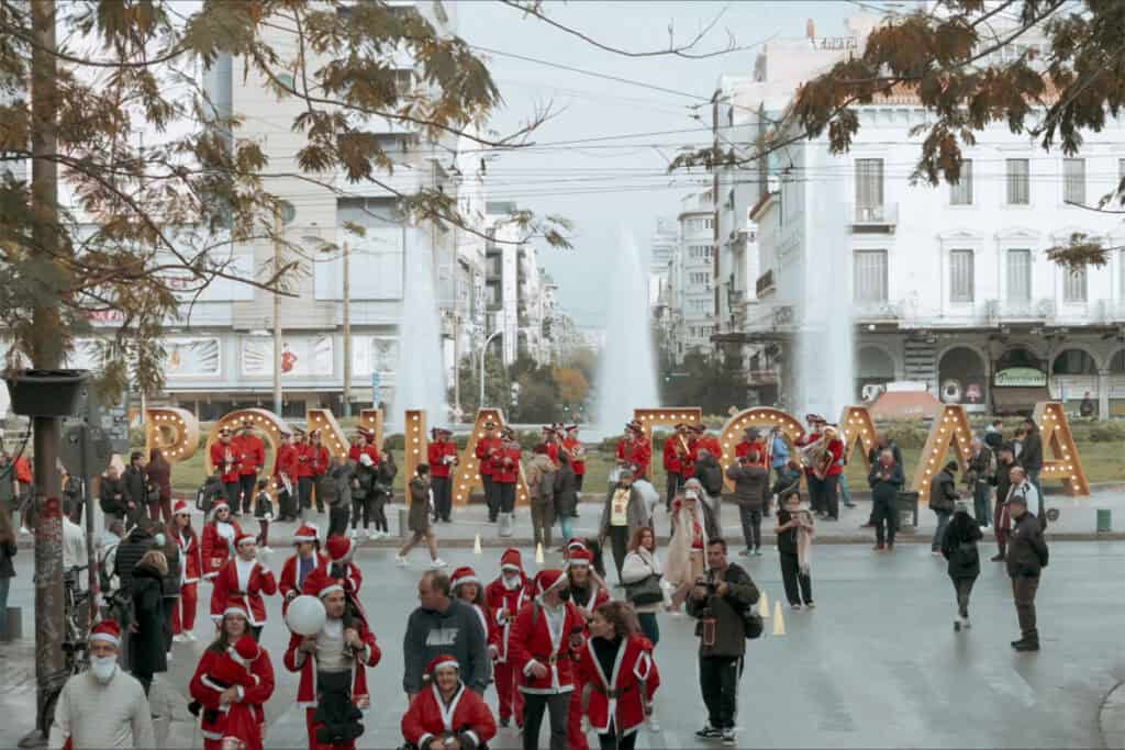 Runners dressed as Santa Claus gather in Omonia Square as a band performs during the Athens Santa Run