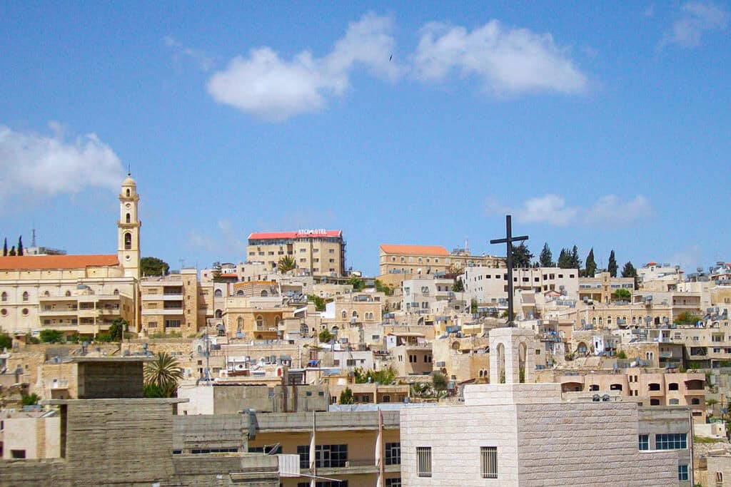 The skyline of Bethlehem in the West Bank, with churches and residential buildings on surrounding hills.