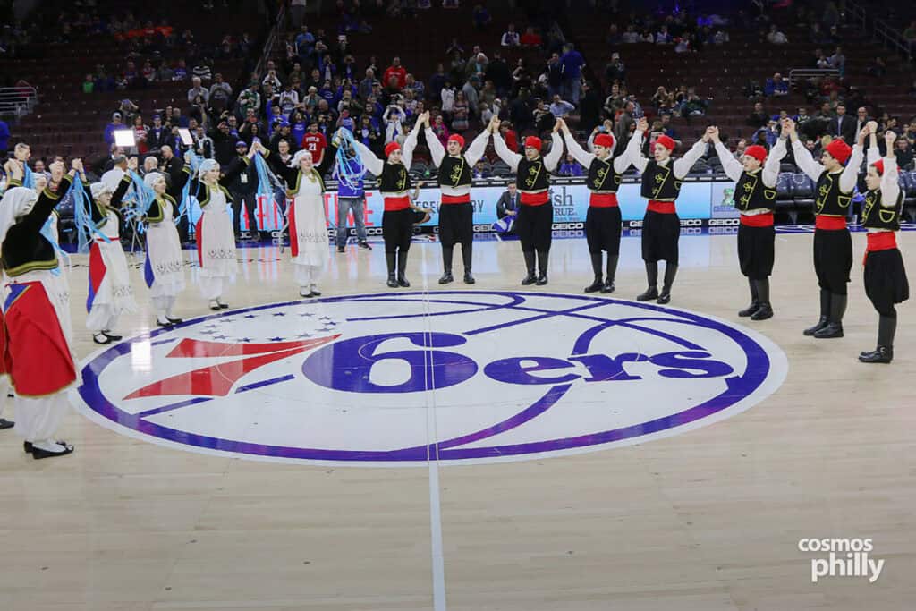 Traditional Greek dancers perform in a circle at center court during halftime at a Philadelphia 76ers Greek Heritage Night.