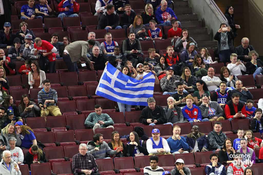Fans in the arena seating section wave a large Greek flag during a Philadelphia 76ers Greek Heritage Night.