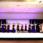 Greek dance group performing on stage during a Music and Dance Festival event.