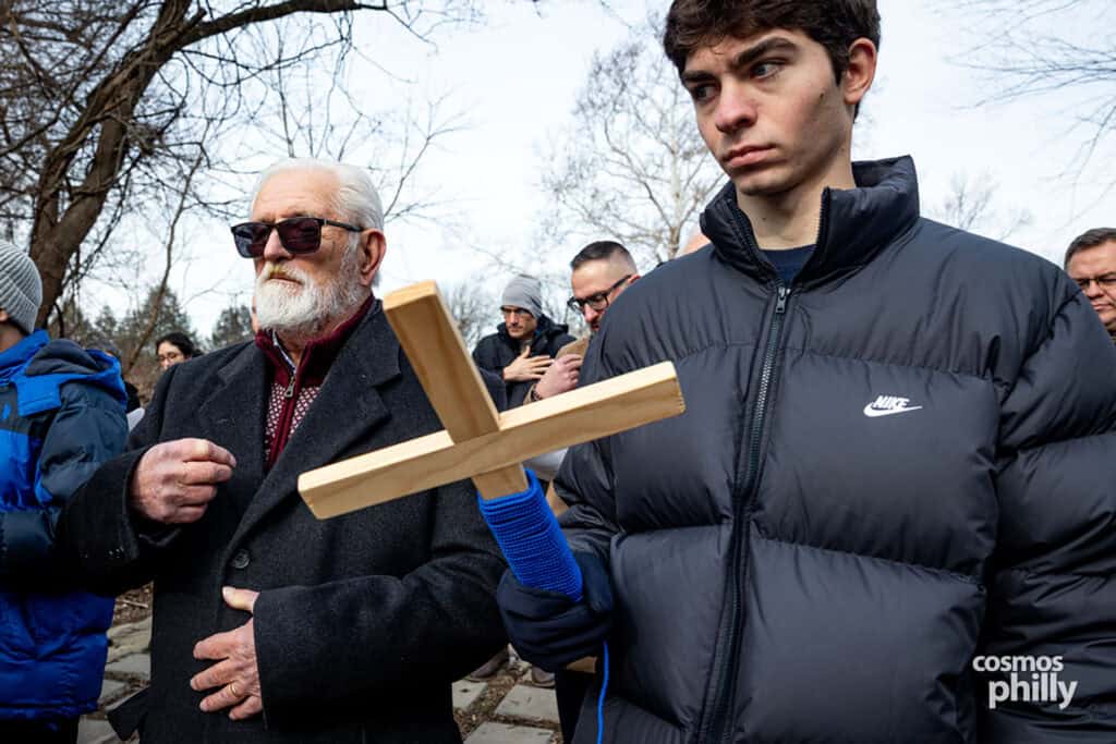 A wooden cross is held by a congregant during the Theophany ceremony by the river.