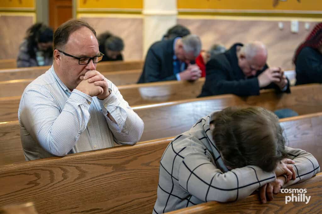 Parishioners bow their heads in prayer inside the church during the Theophany liturgy.