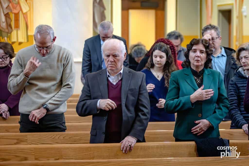 Members of the congregation make the sign of the cross during the Orthodox Theophany service.