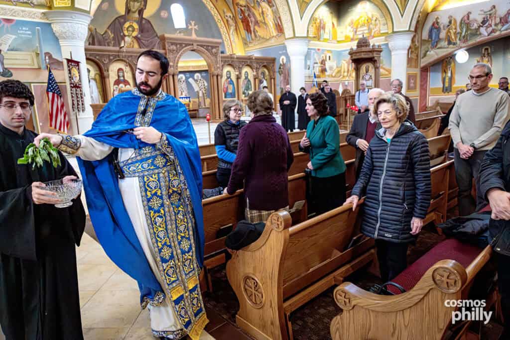 Clergy distribute holy water to parishioners inside the church after the blessing.