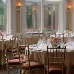 Banquet hall interior at Vivo! in Bayside, New York, arranged with round tables and place settings.