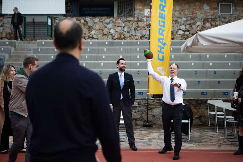 An official throws a football during a ceremonial moment at the Los Angeles Chargers flag football event in Athens.