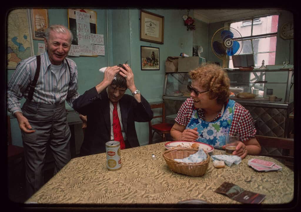 Man and woman seated at a table sharing a moment in a modest dining room