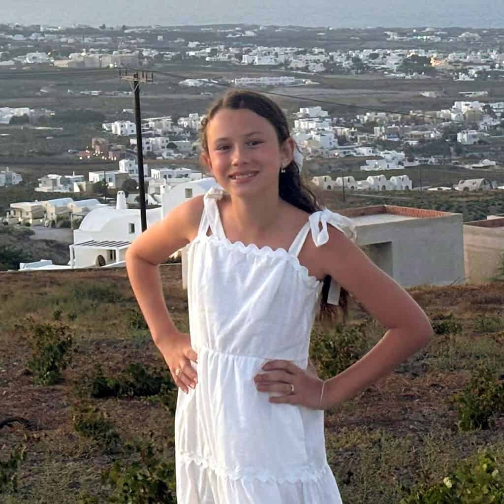 Georgia Elena overlooking a Greek island landscape during a summer visit.