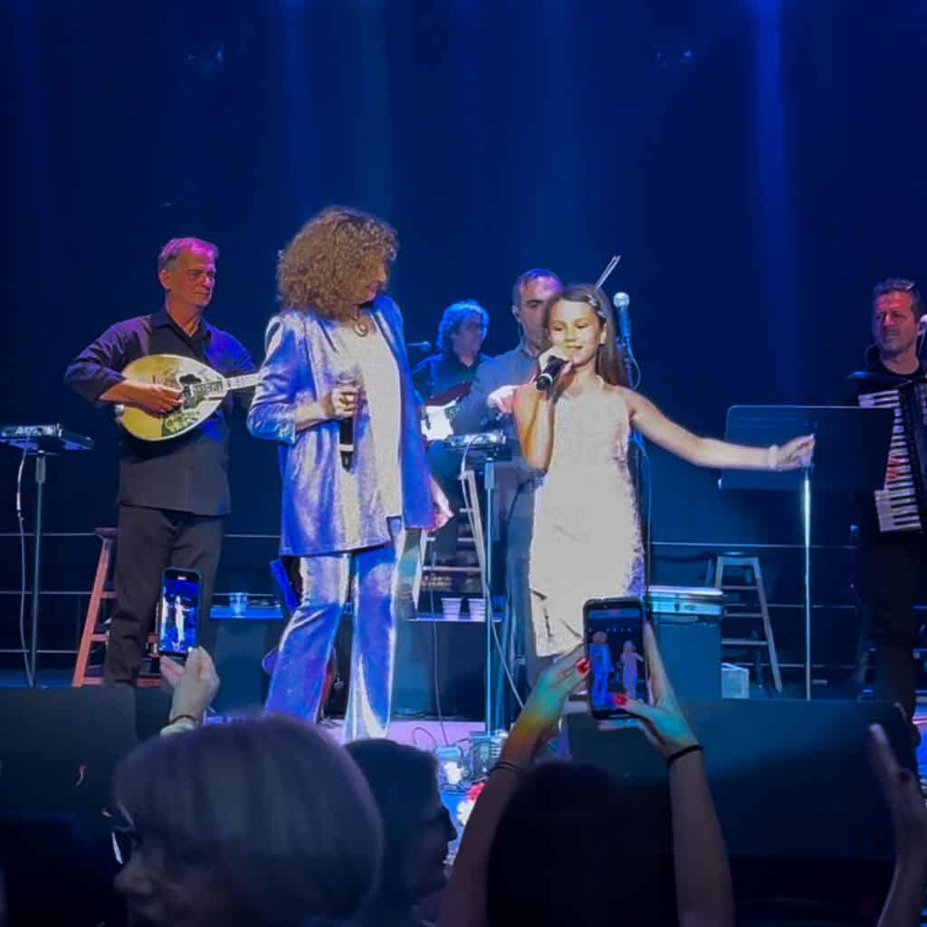 Georgia Elena performing on stage with Greek singer Glykeria during a concert.