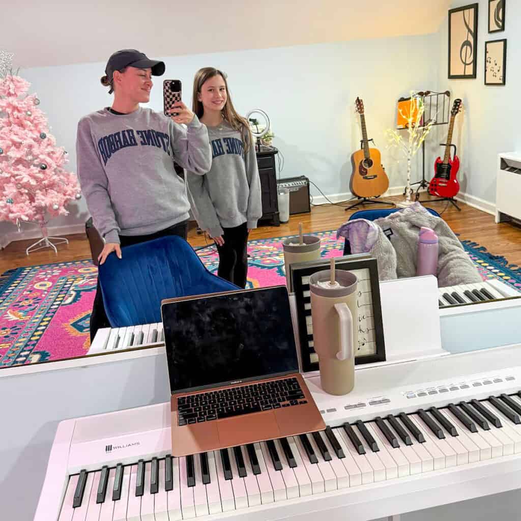 Georgia Elena practicing music at home in New Jersey with piano and guitars nearby.
