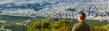 Man overlooking Athens cityscape from a hilltop viewpoint
