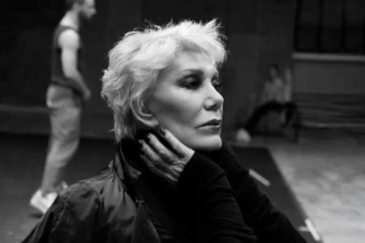 Marinella in a black and white portrait, resting her hand on her neck during a rehearsal setting