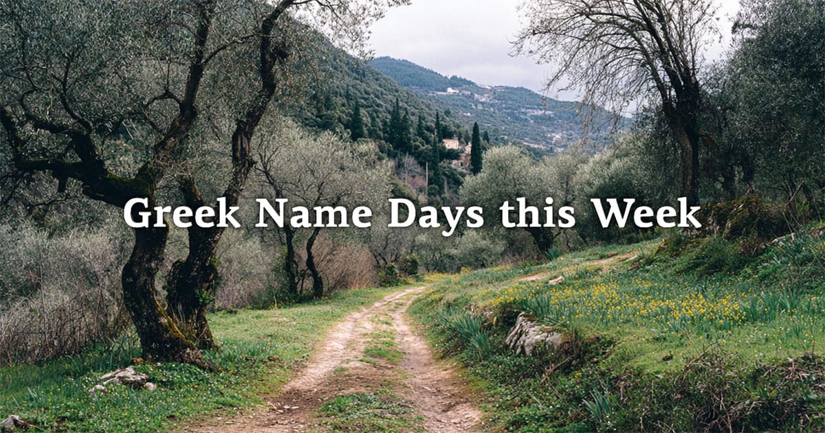 Dirt path winding through a Greek olive grove with hills and countryside in the background.
