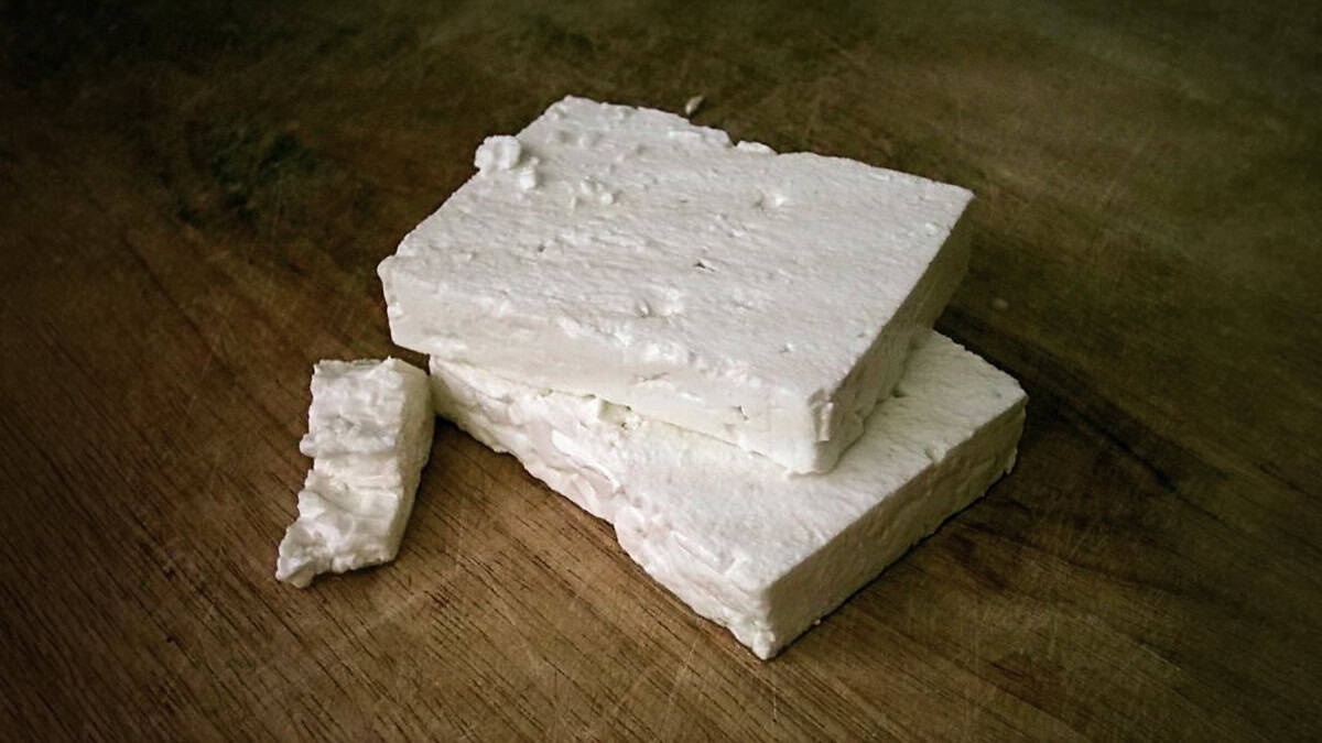 Blocks of traditional Greek feta cheese on a wooden surface