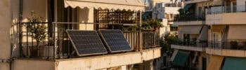 Small solar panels mounted on the balcony of a Greek apartment building.
