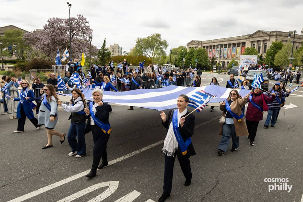 Participants carrying Greek flags during the annual Greek Independence Day Parade in Philadelphia.