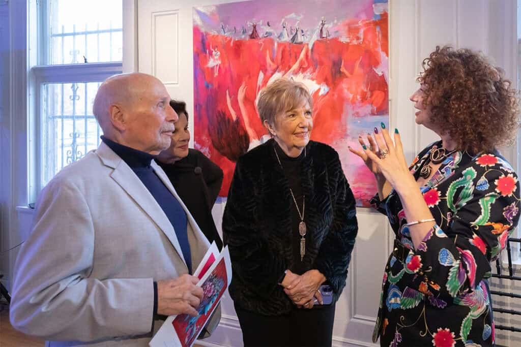 Artist Ramona Pintea speaking with visitors at the exhibition