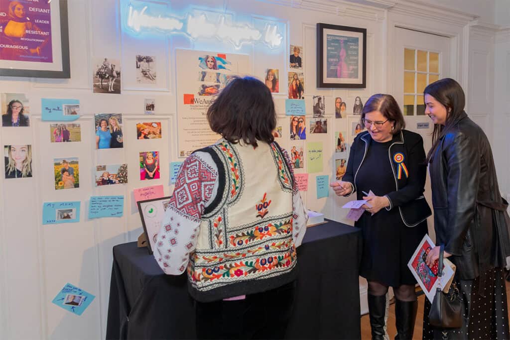 Visitors adding notes and messages to the Women Who Inspire Us wall installation at the Hellenic Museum of Michigan