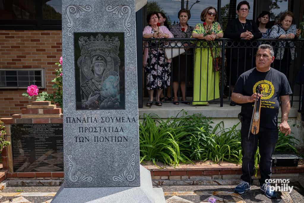 Christos Tiktapanidis stands with a Pontian lyra beside the Panagia Soumela monument during the commemoration.