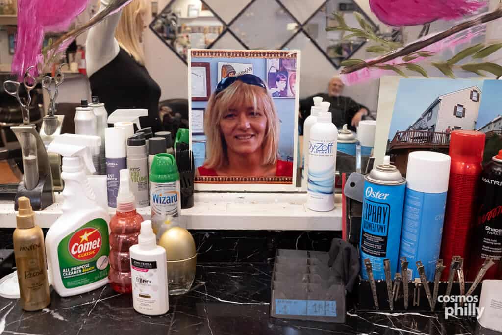 A framed photo of Giota displayed among hair products and tools at her barbershop station in Media.