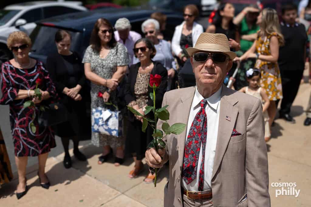 An elderly man holds a red rose during the Pontian Genocide commemoration at St. Demetrios in Upper Darby.