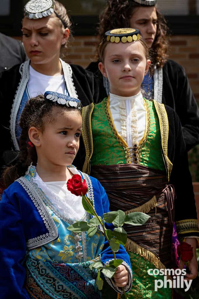 Children in traditional Pontian clothing hold red roses during the Pontian Genocide commemoration.