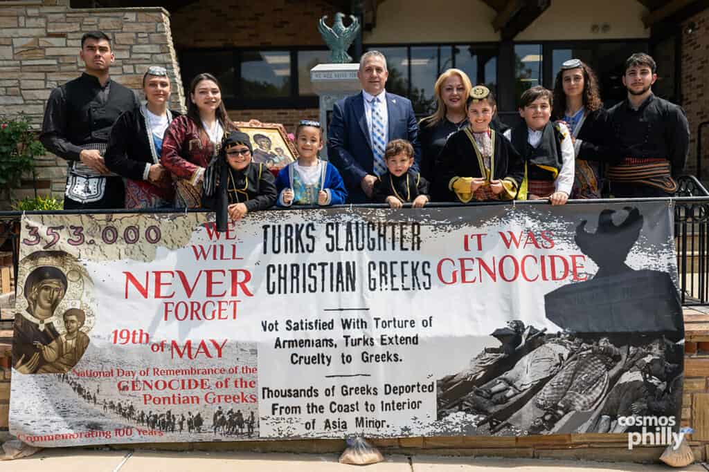 Pontian youth and community members stand behind a banner marking May 19 as the day of remembrance for the Pontian Genocide.