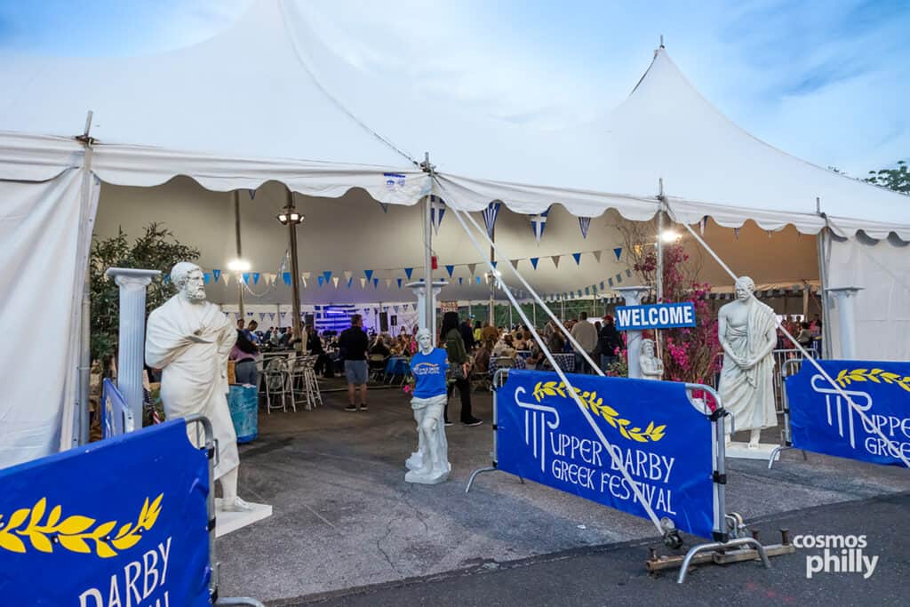 Scenes from the St. Demetrios Greek Wine and Food Festival in Upper Darby, with guests, food, dancing, volunteers, and activity under the festival tent.