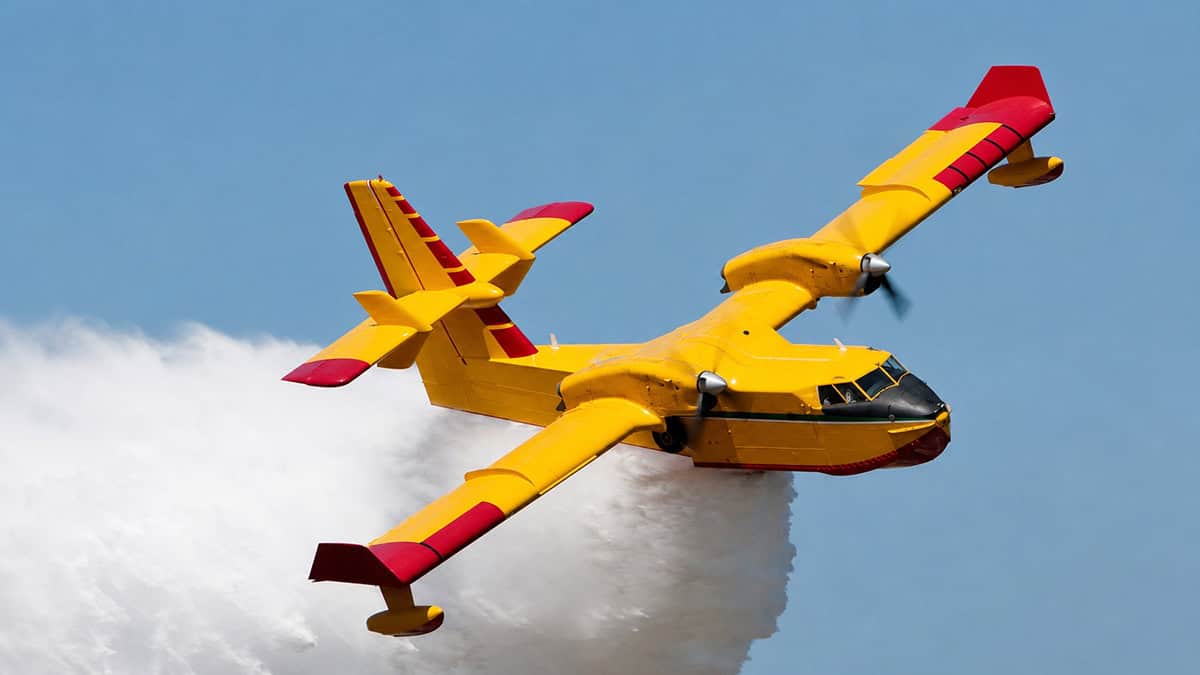 Firefighting aircraft releasing water during an aerial wildfire response.