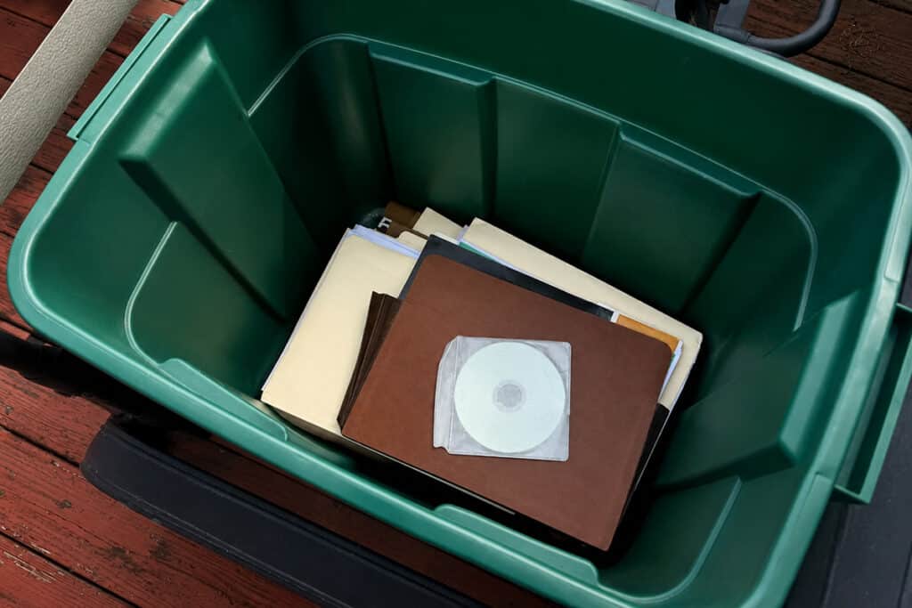A green storage bin holding albums, folders, and discs from the Eleftheria VFW Post 6633 archive.