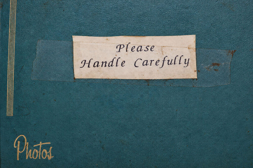 A worn photo album labeled “Please Handle Carefully” from the Eleftheria VFW Post 6633 archive.