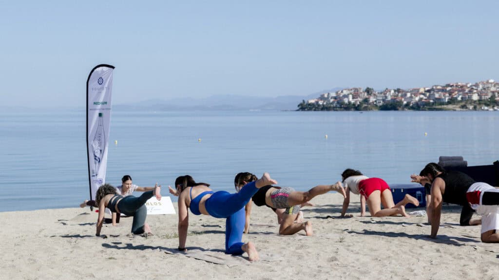 Participants take part in a yoga session by the sea during Porto Carras Athlos.