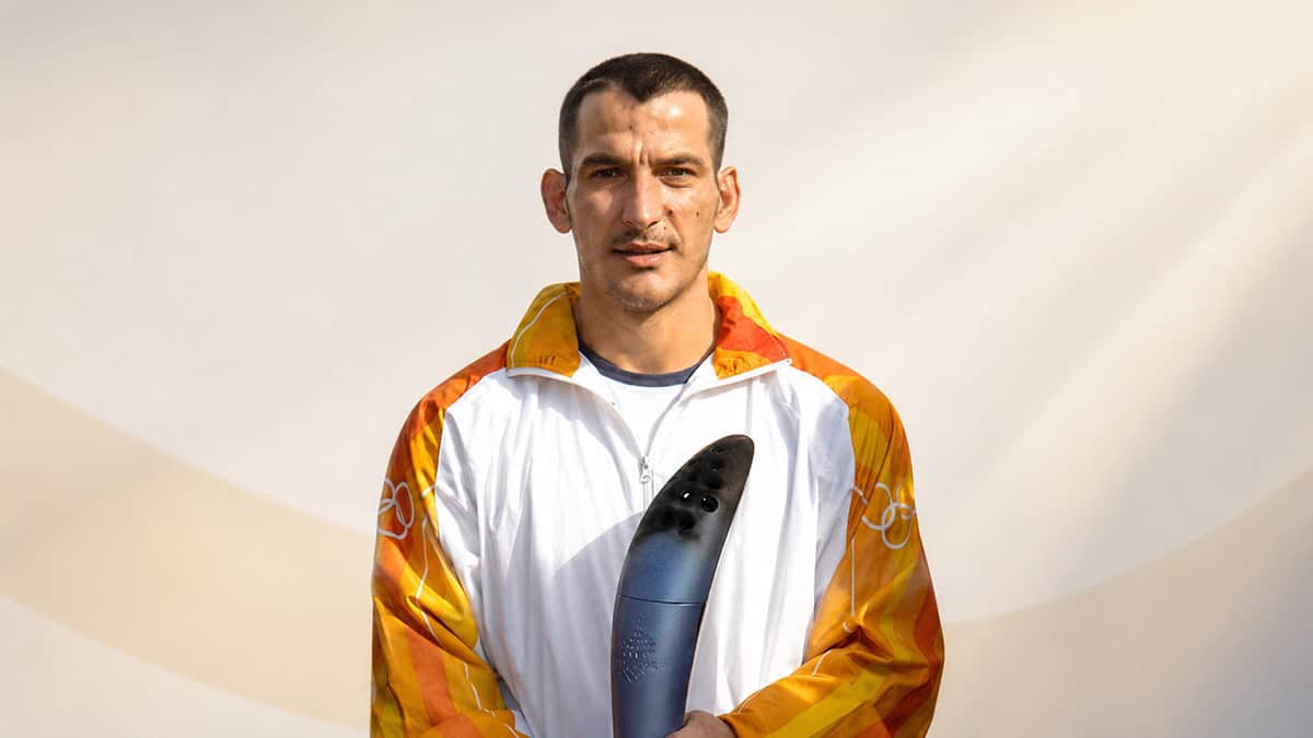 Pyrros Dimas holding an Olympic torch during a 2005 event in Dion, Greece
